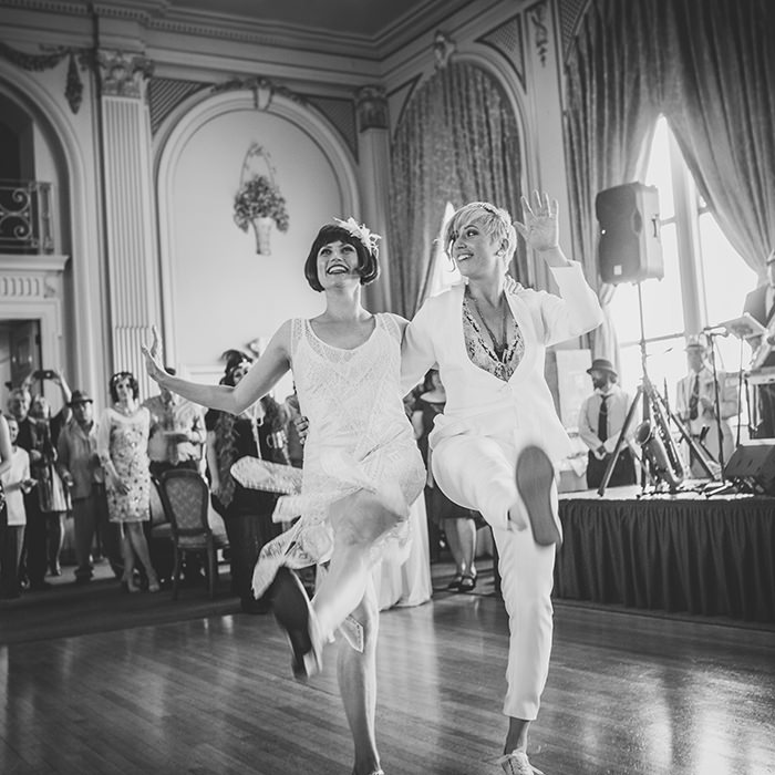 Black and white photo of two brides dancing at their Bellevue Club wedding in Oakland – A romantic and timeless moment as the newlyweds share a joyful dance