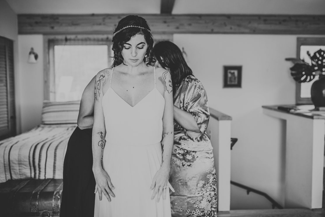 Bride putting on her dress at creative Stinson beach wedding by Becca Henry Photography