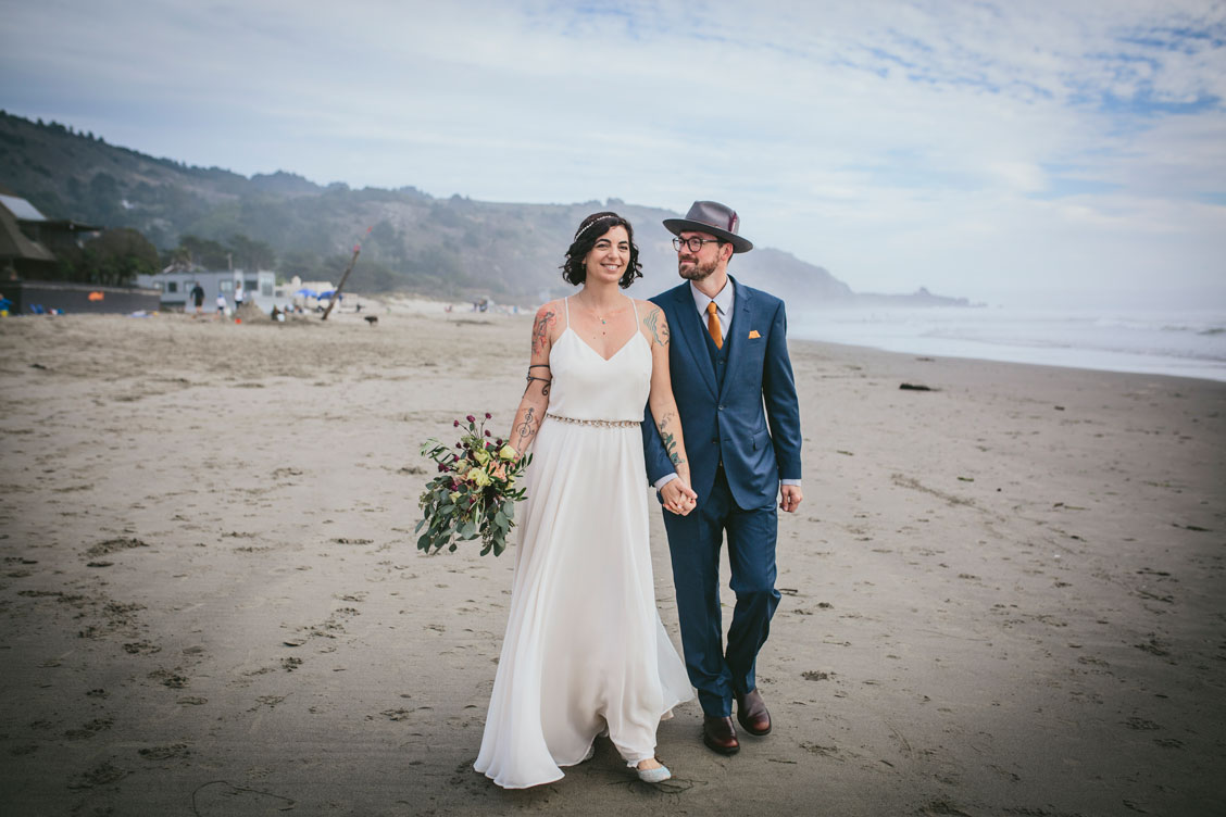 Wedding couple walks on the beach at Stinson Beach wedding by Becca Henry photography