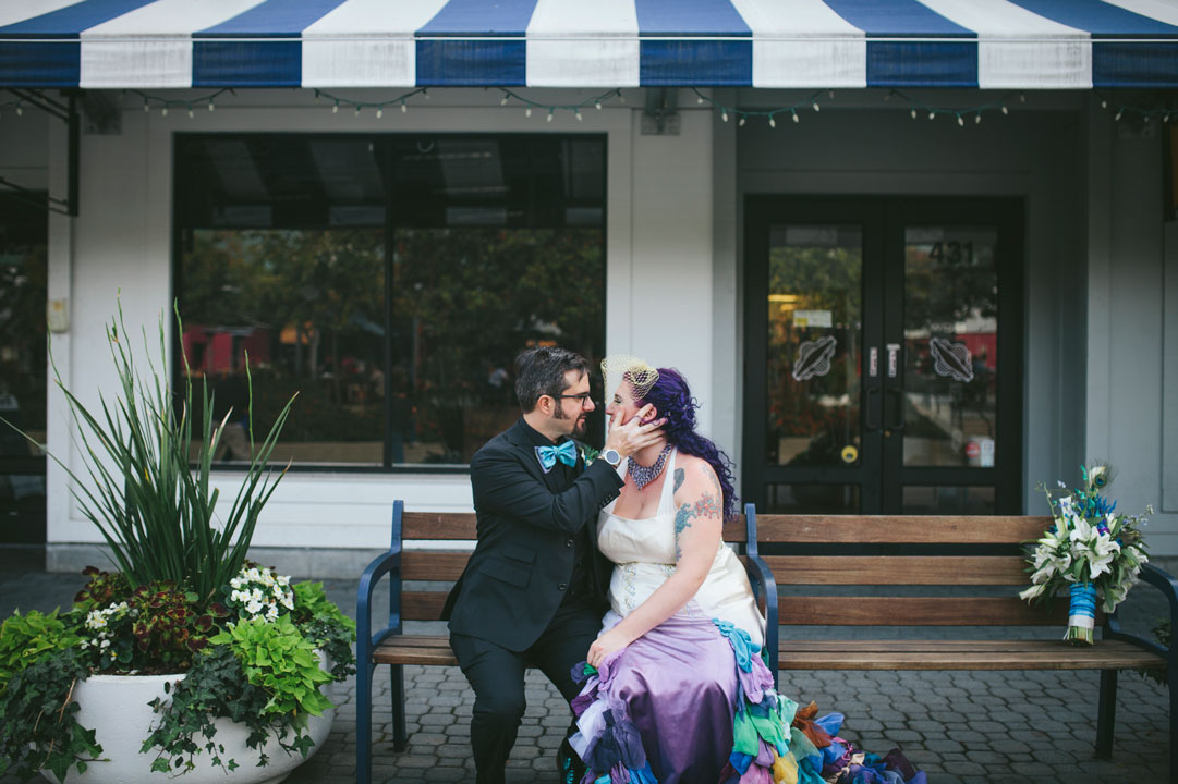 Alternative wedding- couple snuggles on bench in Jack London Square by Becca Henry Photography