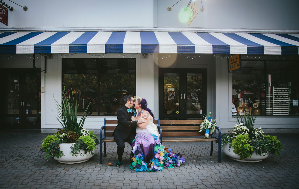 Alternative wedding- couple snuggles on bench in Jack London Square by Becca Henry Photography