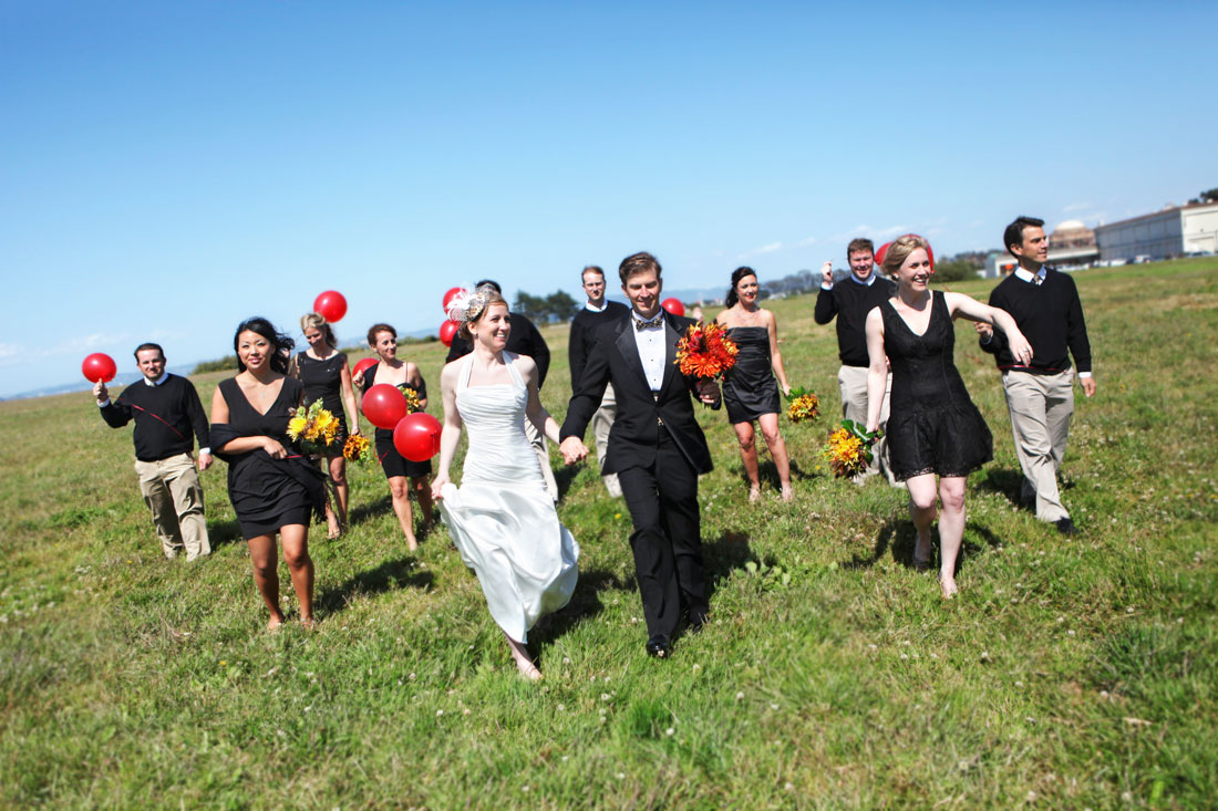 Wedding party in the Presidio with red balloons against a blue sky by Becca Henry Photography