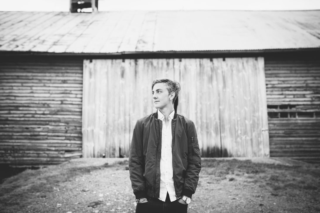 BW portrait of a young man in front of barn in Virginia by Becca Henry Photography