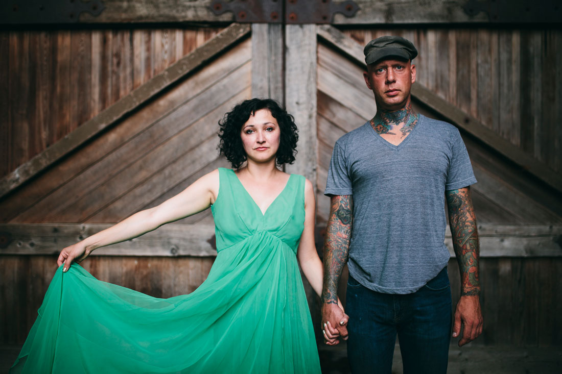 Couple in striking green dress and tats holding hands by Becca Henry Photography