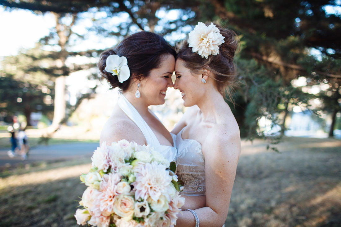 Two beautiful brides under the trees at Alamo Square in San Francisco by Becca Henry Photography