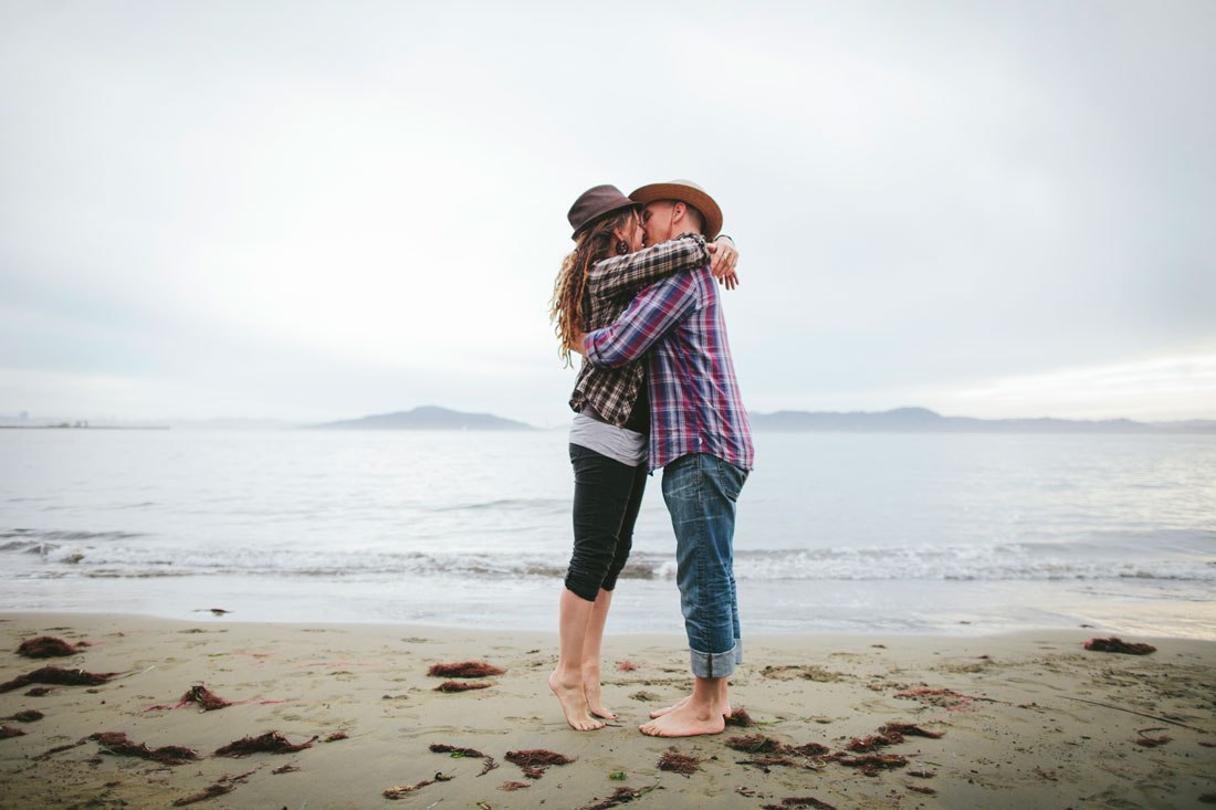 California casual engagement session- couple on tippy toes kissing on the beach by Becca Henry Photography