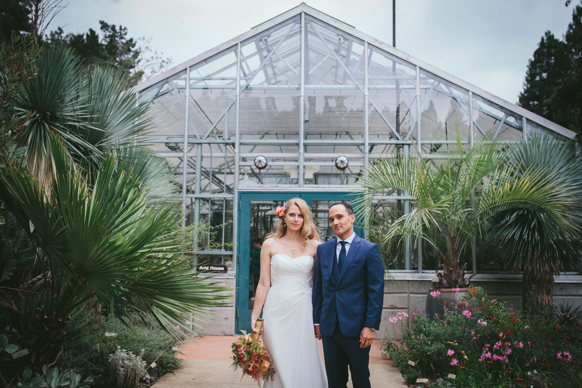 Bride and groom in front of greenhouse at Berkeley Botanical Garden by Becca Henry Photography
