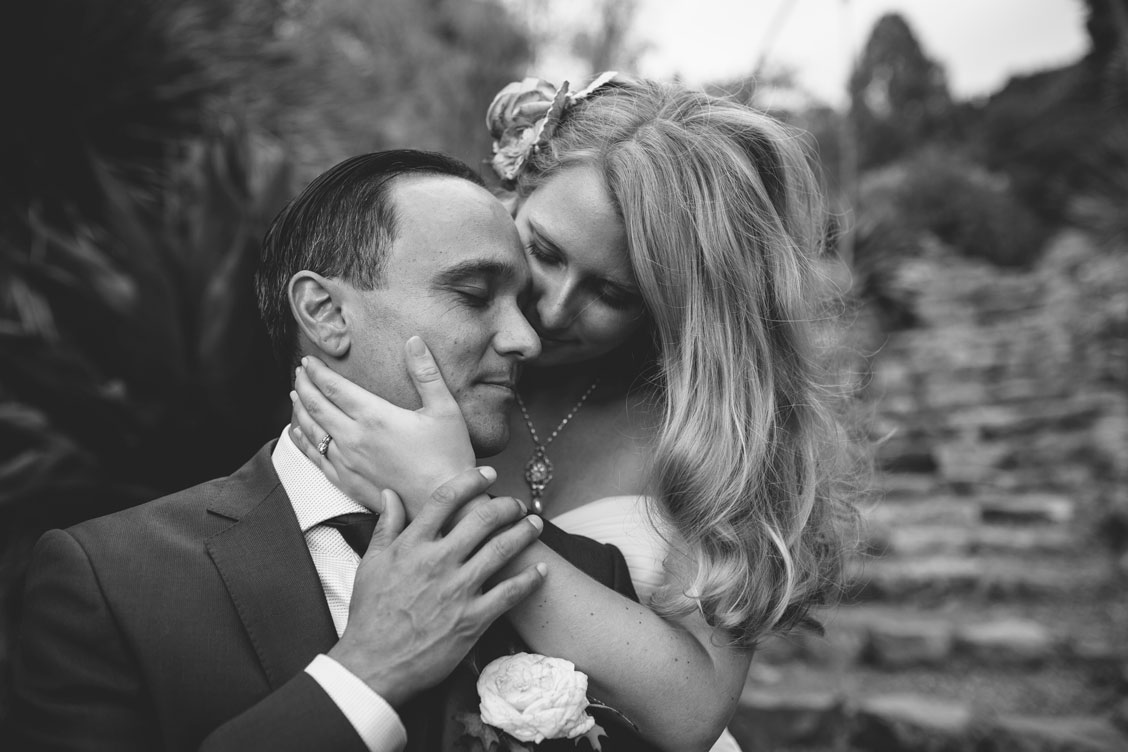 Bride caresses groom's cheek at Berkeley Botanical Garden by Becca Henry Photography