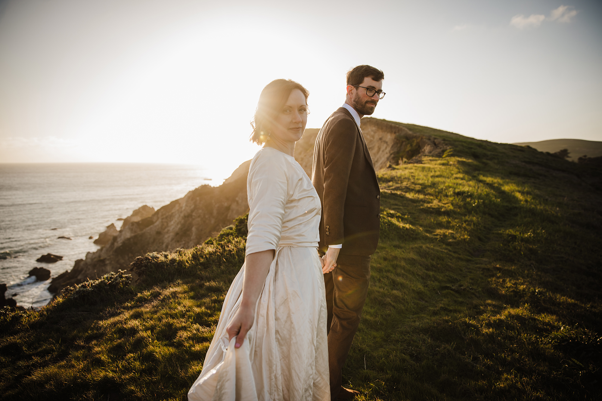 Walking through the hillside at sunset during their Point Reyes elopement.