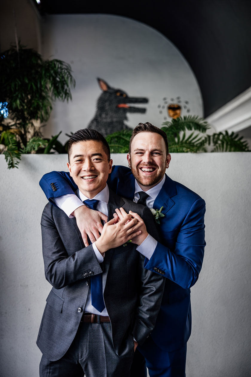 San Francisco same sex wedding - photos of the 2 grooms in front of cool mural