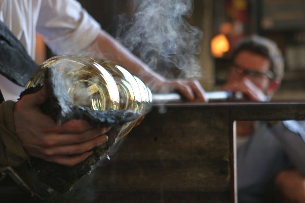 Elegant branding photography showcasing a person pouring a drink with smoke effects.