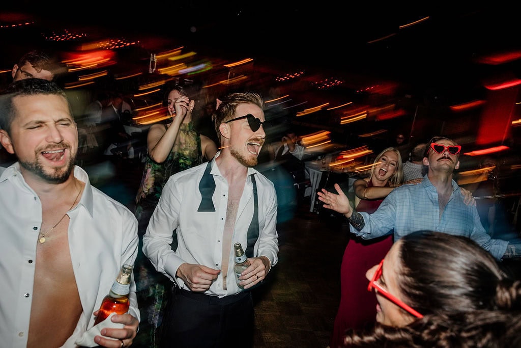People enjoying a lively party with drinks and dancing at a corporate event.